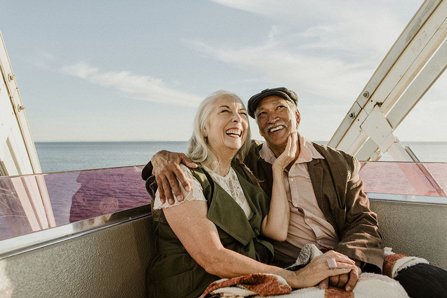 Employee Benefits - Smiling Elderly Couple Riding a Ferris Wheel and Enjoying Their Retirement